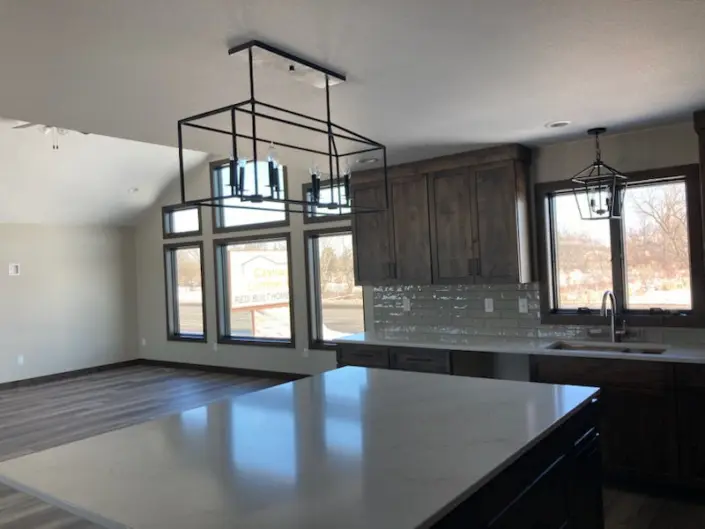 Custom Redi-Built home kitchen with wood cabinetry, large island and pendant lighting