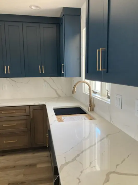 Custom sink area with blue cabinets and white countertops in a Redi-Built home
