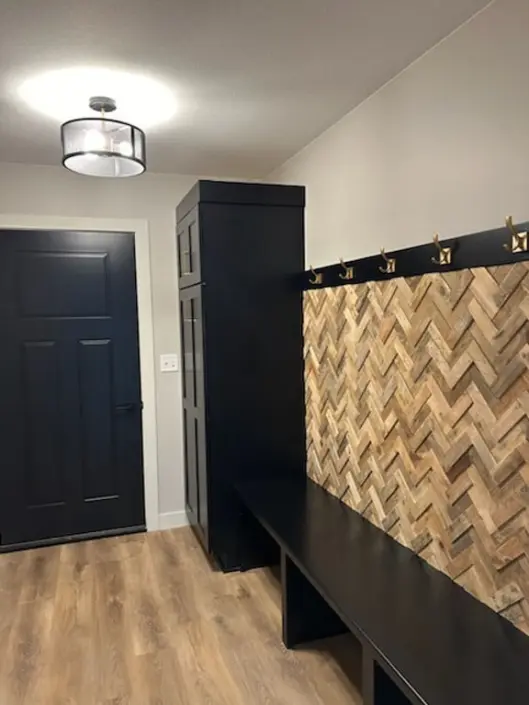 Mudroom with built-in bench and herringbone wood accent wall in a custom Redi-Built home