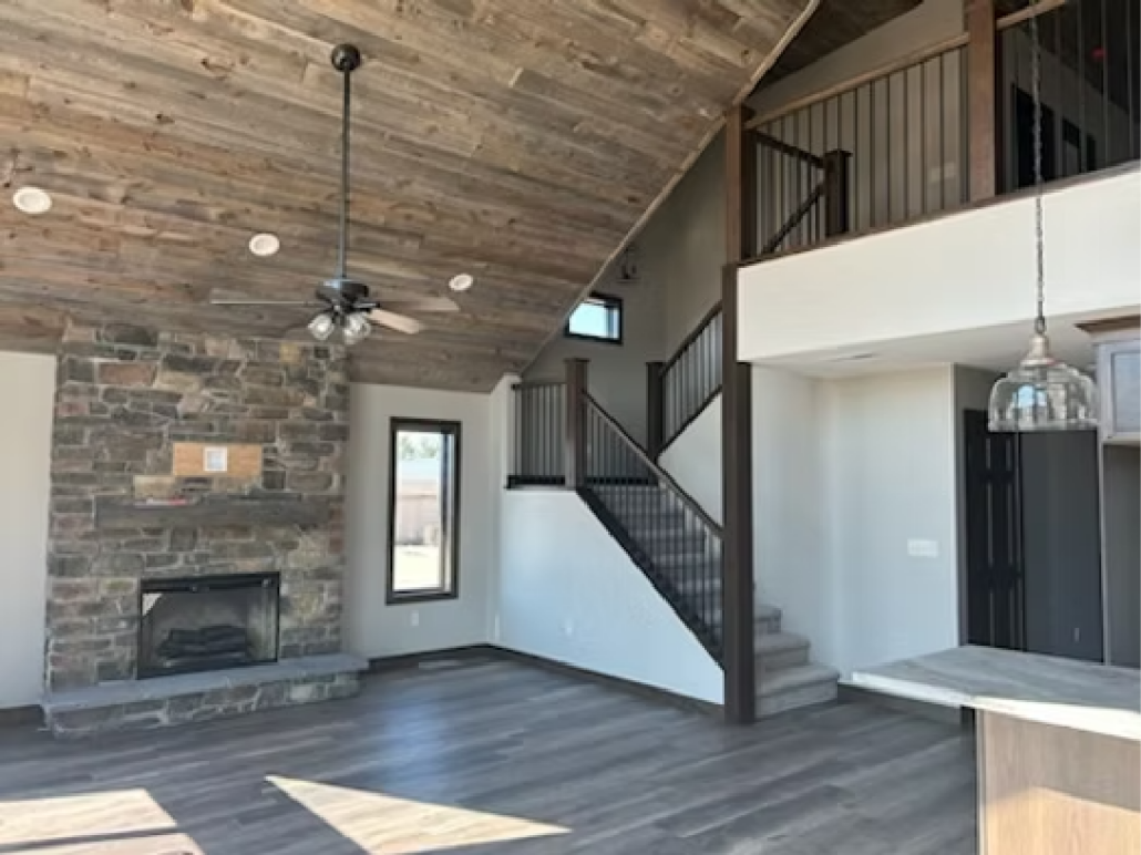 Interior of a Redi-Built home in South Dakota with vaulted wood ceiling and stone fireplace